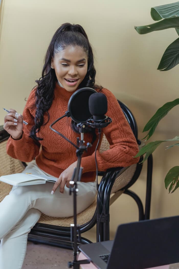 Woman using studio microphone for podcast